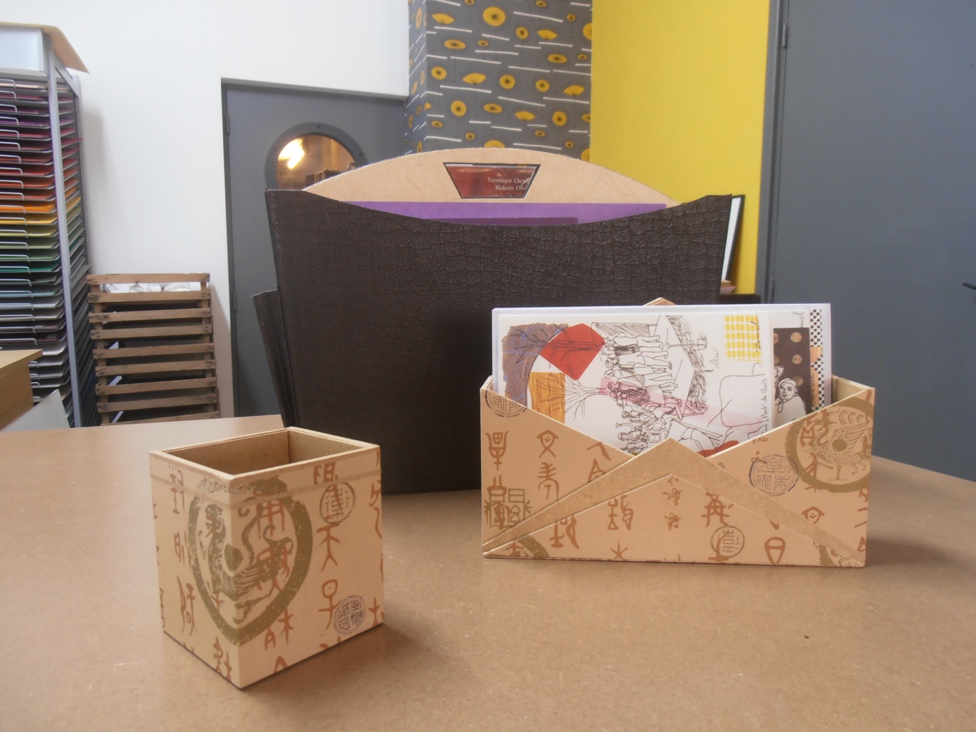 Cartonnages réalisés à l'atelier, devant les rangements de papiers